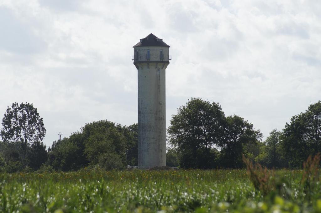 a tower in the middle of a field at chateau d'eau le sable in Daon