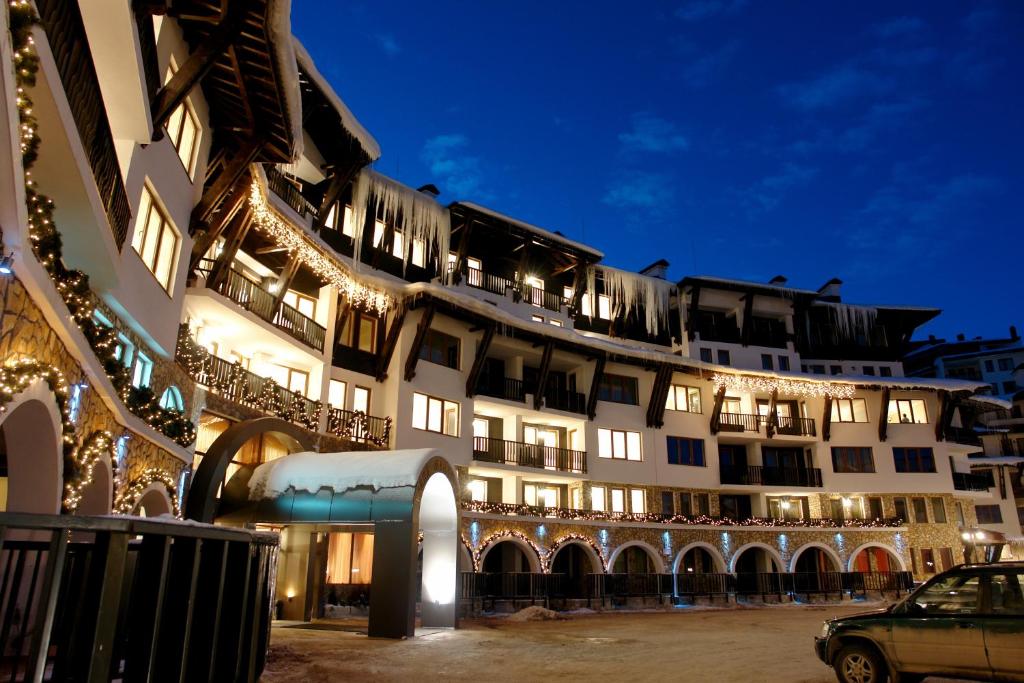 a large white building with christmas lights on it at Grand Monastery Private Apartments in Pamporovo