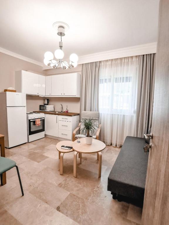 ein Wohnzimmer mit einem Tisch und einer Küche in der Unterkunft TIP TOP apartment in Chalkida