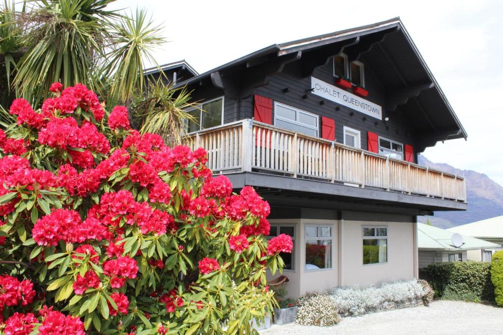 un edificio con fiori rosa di fronte di Chalet Queenstown a Queenstown