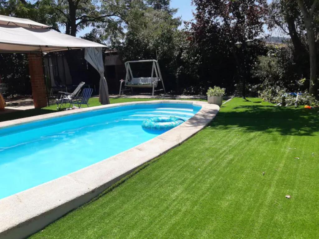 ein Pool in einem Garten mit grünem Gras in der Unterkunft Casa Rural con Piscina y AA en Sierra Oeste de Madrid in Pelayos de la Presa