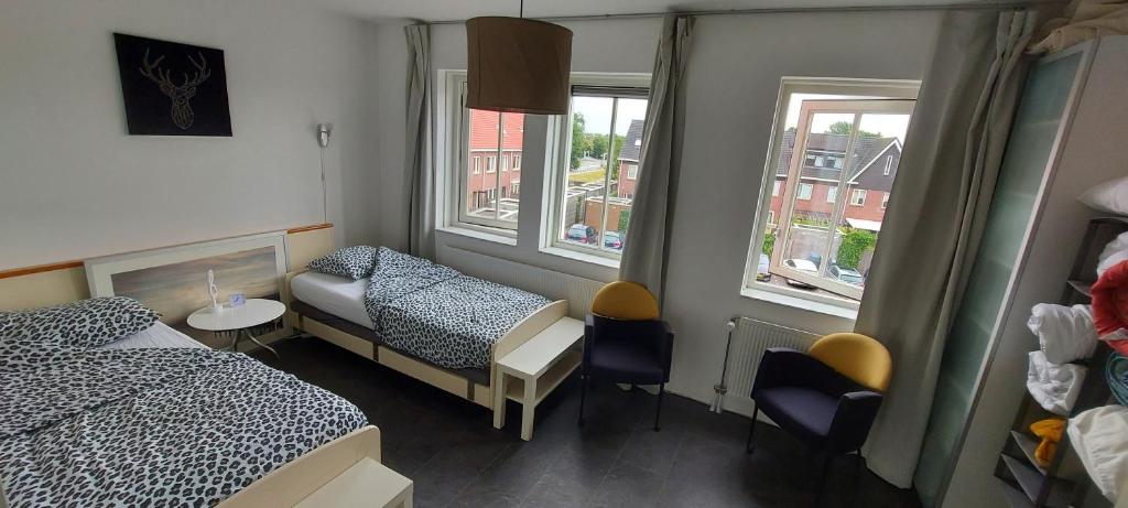 Cette petite chambre comprend 2 lits et une fenêtre. dans l'établissement Airbnb 'Logeren aan het plein' in het centrum van Meppel, à Meppel