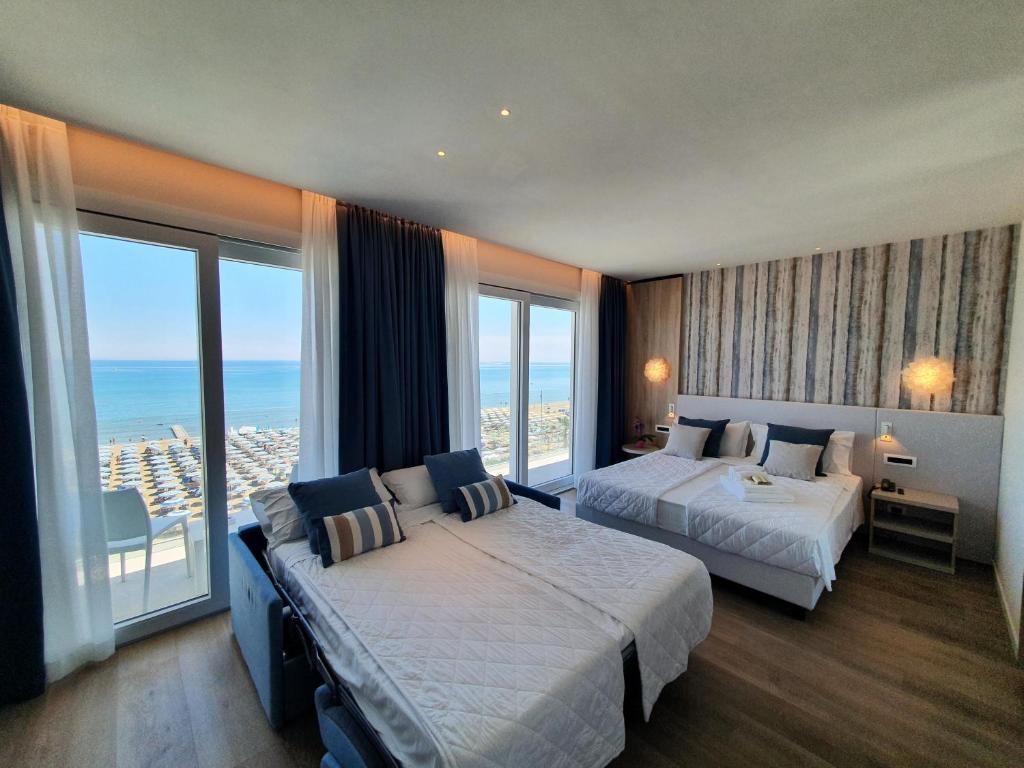 a hotel room with two beds and a large window at Hotel Galassia Suites & Spa in Lido di Jesolo