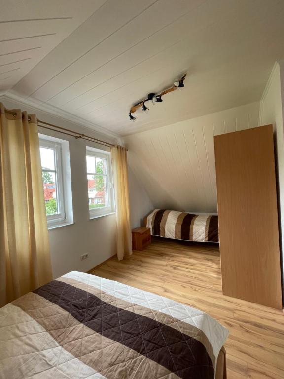 a bedroom with a bed and two windows at Ferienwohnung Justus in Aurich