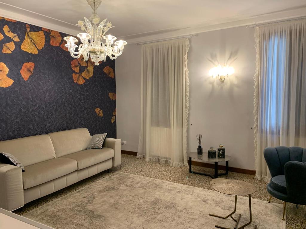 sala de estar con sofá y lámpara de araña en San Marco Charming Suite, en Venecia