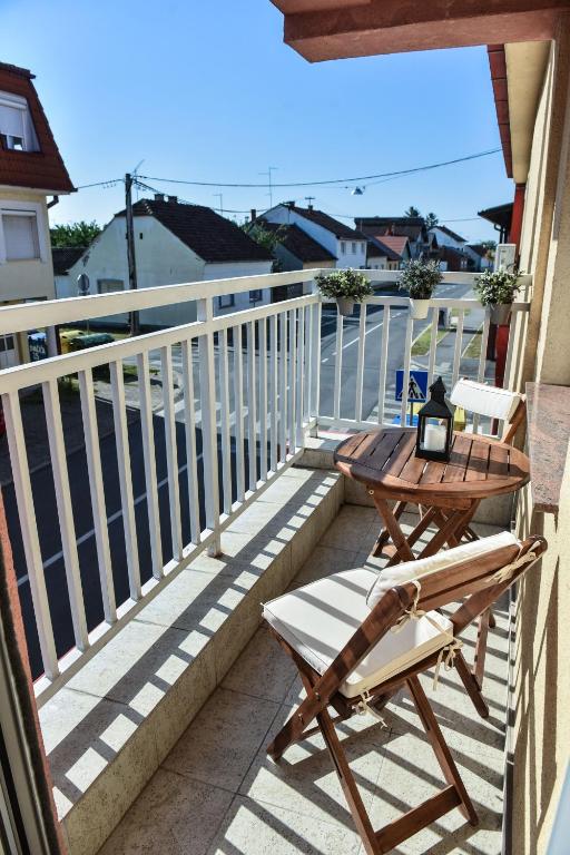 a wooden table and a chair on a balcony at DORA in Đakovo