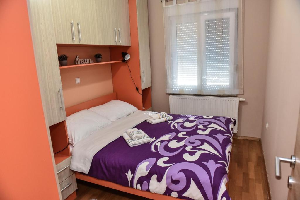 a small bedroom with a bed and a window at DORA in Ðakovo