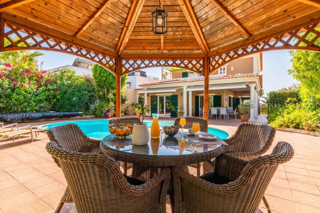 a patio with a table and chairs and a pool at Villa Ferragudo, Piscina e Mesa de Bilhar! in Ferragudo