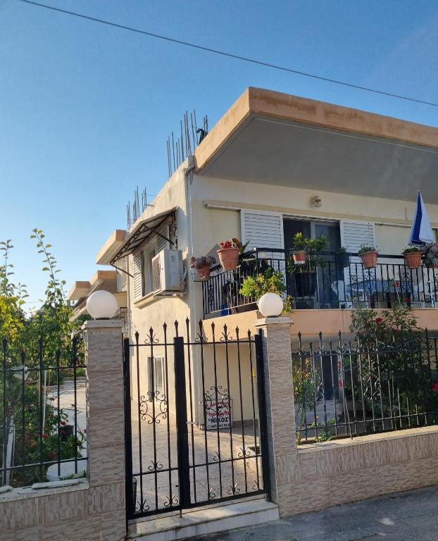 a house with a wrought iron fence in front of it at Eleni's Apartments in Nea Iraklia
