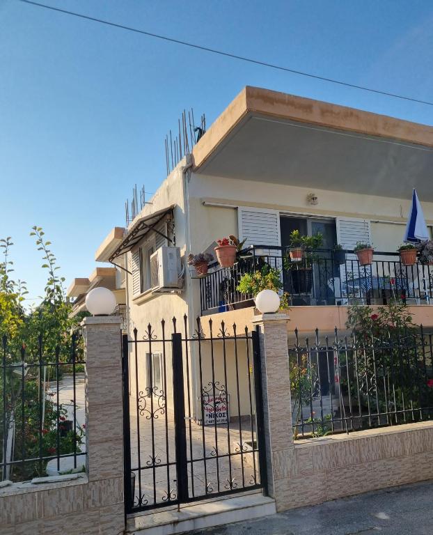 a house with a wrought iron fence in front of it at Eleni's Apartments in Nea Irakleia