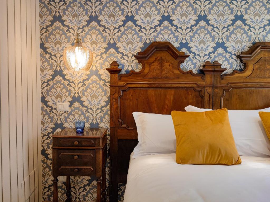 Da Pardis في بيرغامو: غرفة نوم بسرير من اللوح الخشبي وطاولة جانبية