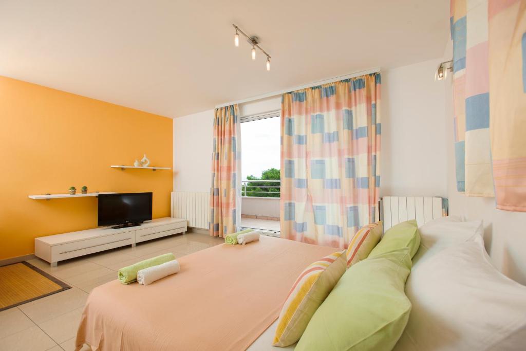 un soggiorno con un grande letto e una TV di Room in Apartment - Cosy and modern family apartment for 4 a Promajna