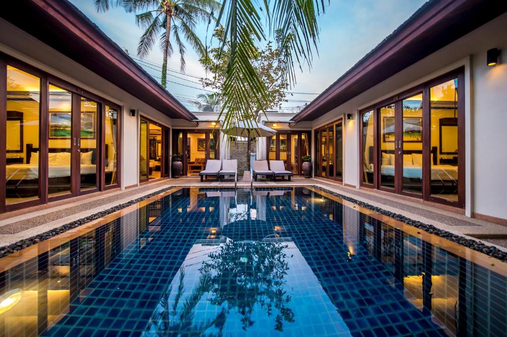 einen Pool in einer Villa mit einem Resort in der Unterkunft Pai Tan Villas - SHA Extra Plus in Strand Bang Tao
