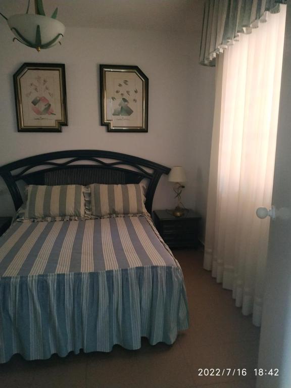 sypialnia z łóżkiem z narzutą w obiekcie HUELVA PLAYAS DEL SUR w mieście El Portil
