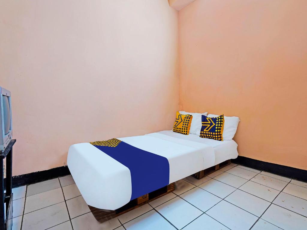 Un pat sau paturi într-o cameră la SPOT ON 91367 Rumah Bundo Syariah