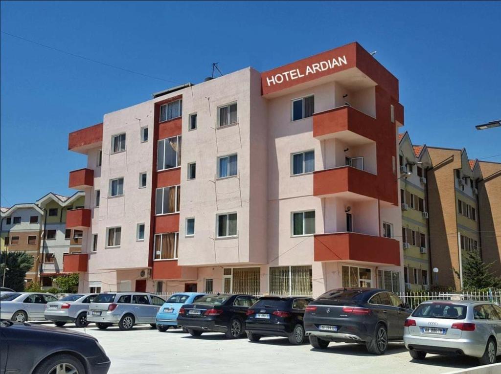 a building with cars parked in a parking lot at Hotel Ardian in Golem