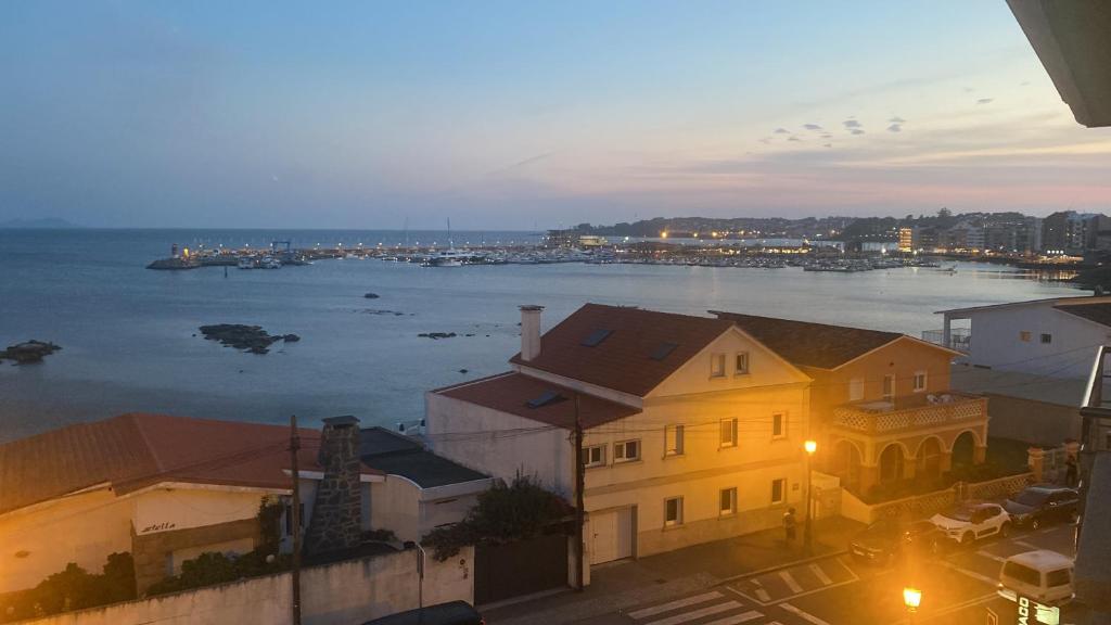 a view of the ocean from a building at night at precioso apartamento con vistas al mar in Sanxenxo