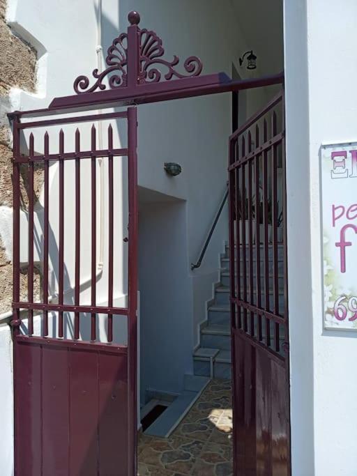 a red door leading into a hallway with stairs at studio SUCCÈS in Pylos