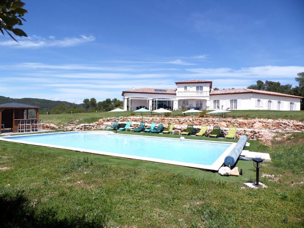 a swimming pool in front of a house at Villa 342 m2 classée 4 étoiles sur 1 ha - Provence in Besse-sur-Issole