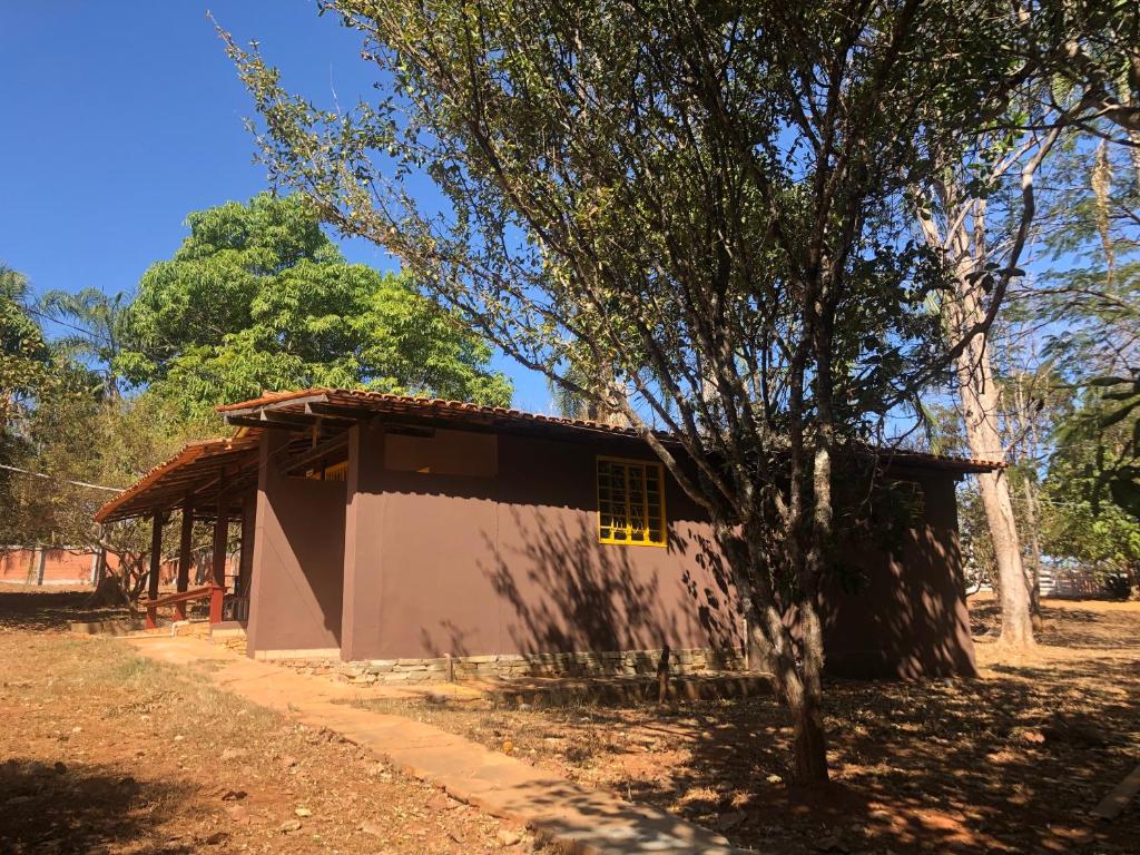 mały domek z drzewem przed nim w obiekcie Estância Agnus Dei w mieście Pirenópolis