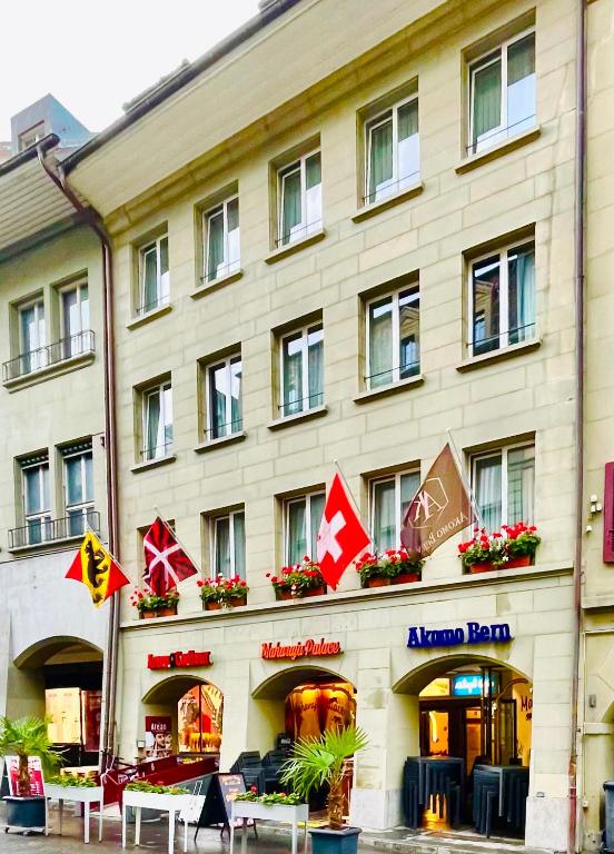 a hotel with tables and chairs in front of it at Akomo Bern in Bern