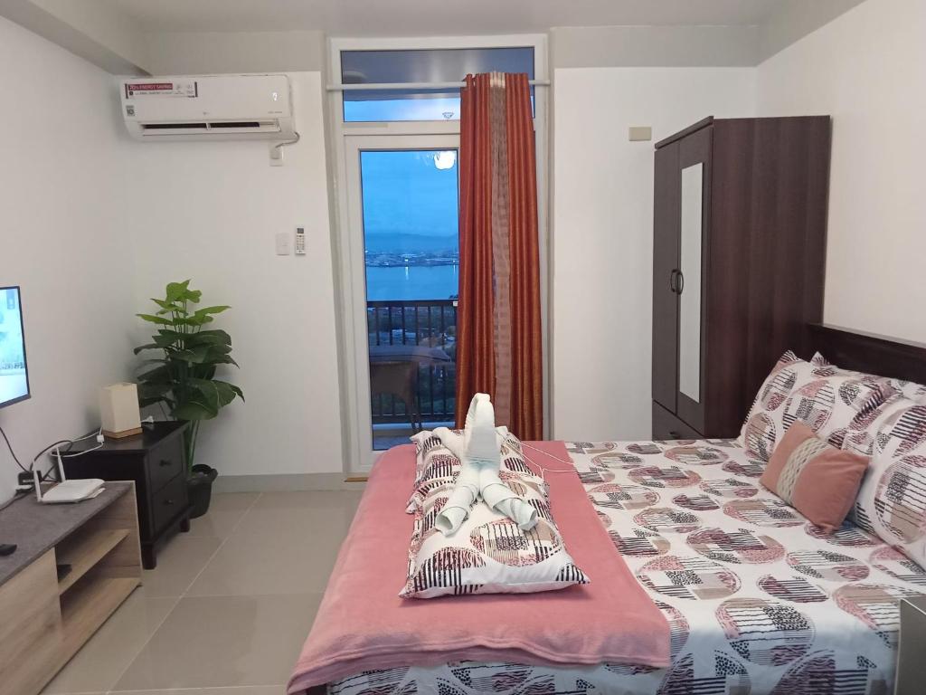 ein Schlafzimmer mit einem Bett und einem großen Fenster in der Unterkunft Saekyung Condominium in Mactan