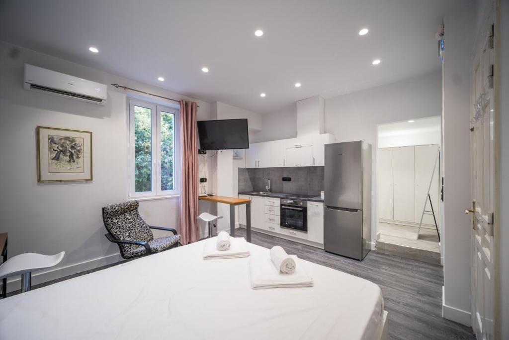 a white room with a kitchen and a table at Studio Reale Corfu in Corfu