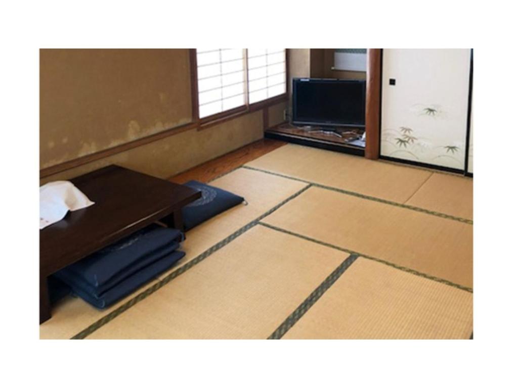 a room with a desk and a table and a table and a room with at Kagetsu Ryokan - Vacation STAY 04880v in Shizuoka