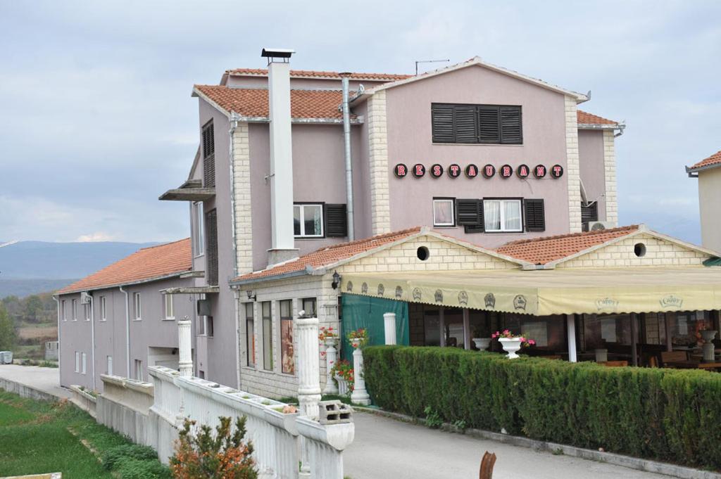 a large white building with a fence in front of it at Restoran i sobe Venezia in Hrvace