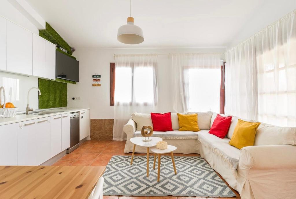 een woonkamer met een witte bank en rode en gele kussens bij Fast wifi & Relax bungalow Ipanema Gran Canaria in Maspalomas