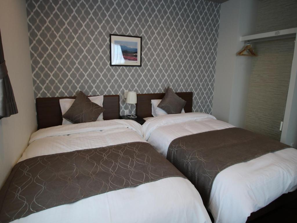 due letti uno accanto all'altro in una camera da letto di SA Inn Ina Nice Road - Vacation STAY 90164v a Ina