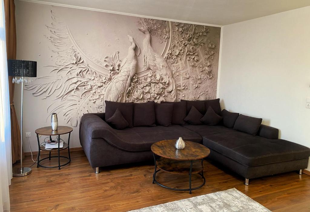 uma sala de estar com um sofá e uma pintura na parede em Cozy Apartment Bernburg 1 em Roschwitz