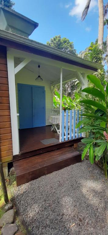 a porch of a house with a wooden deck at Les Gîtes de la Lézarde in Petit-Bourg