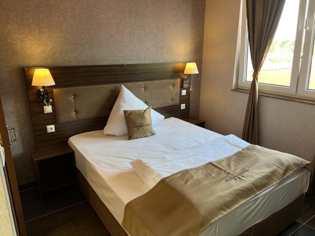 um quarto com uma cama branca com duas almofadas em Hotel Pasa Paradies KOSTENLOSE PARKPLÄTZE em Hanau am Main