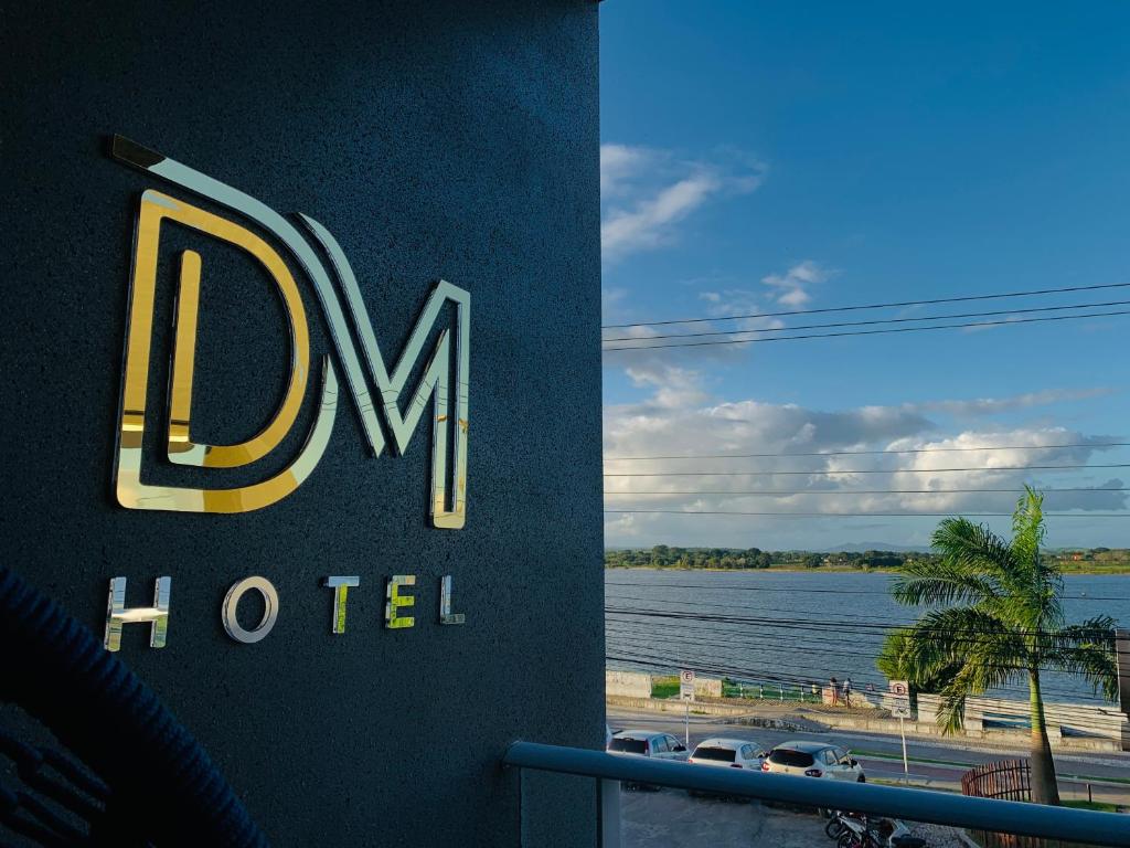 a hotel sign with a view of a body of water at DM HOTEL in Propriá