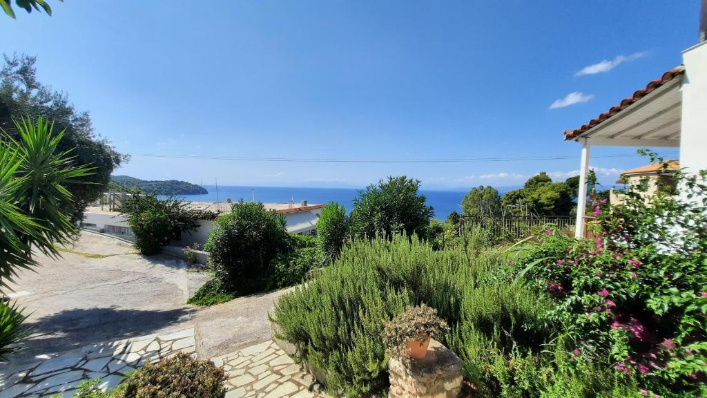 uma vista para um jardim com o oceano ao fundo em Syraino em Kolios
