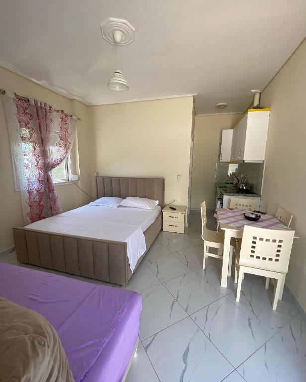 a bedroom with a bed and a table and chairs at Gerard apartments in Sarandë