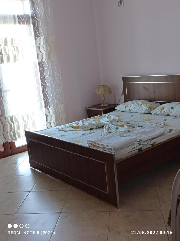 1 dormitorio con 1 cama grande con marco de madera en Guesthouse Fatos Biti, en Divjakë