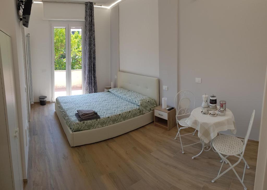 Borgo and Bike في فينالي ليغوري: غرفة نوم بسرير وطاولة وكراسي