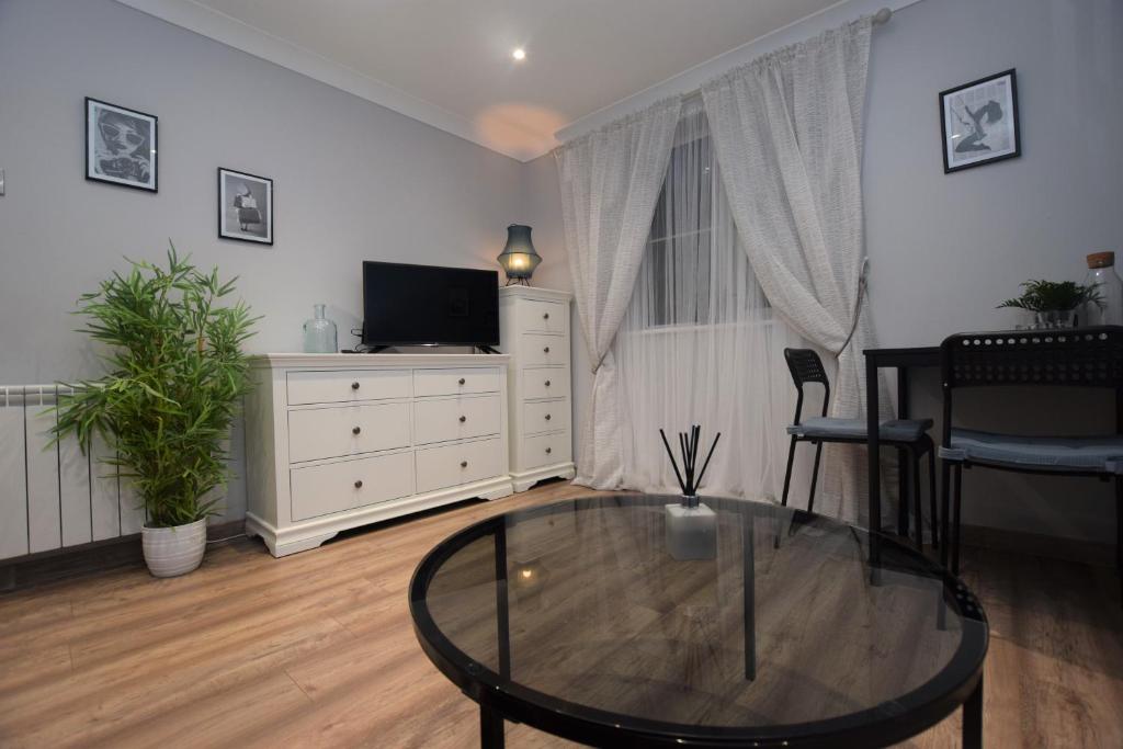 a living room with a glass table and a tv at Lovely Apartment close to the Town Centre & Train Station in Northampton
