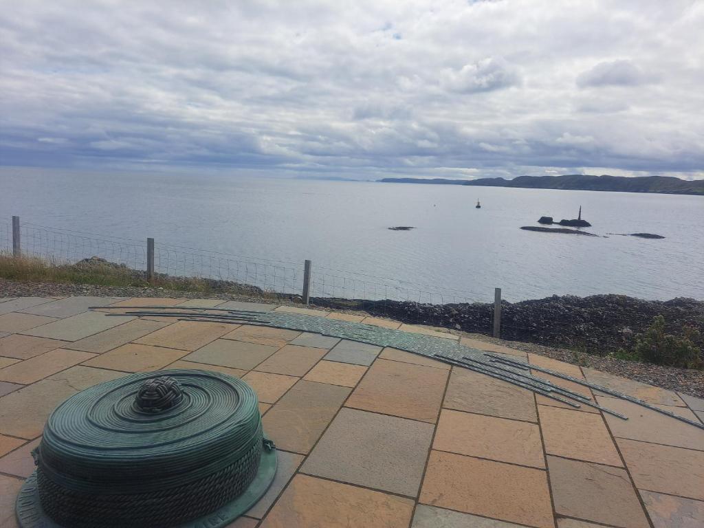 a coil of rope sitting on a patio next to the water at Logan Home in Stornoway