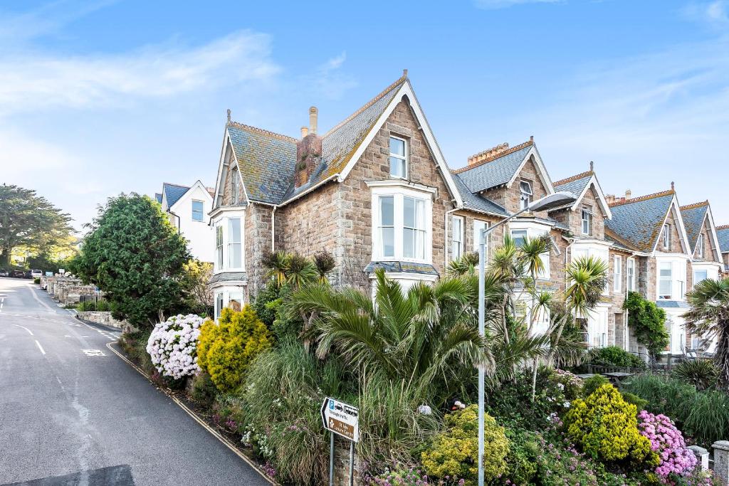 una casa con plantas en flor frente a una calle en organic panda, en St Ives