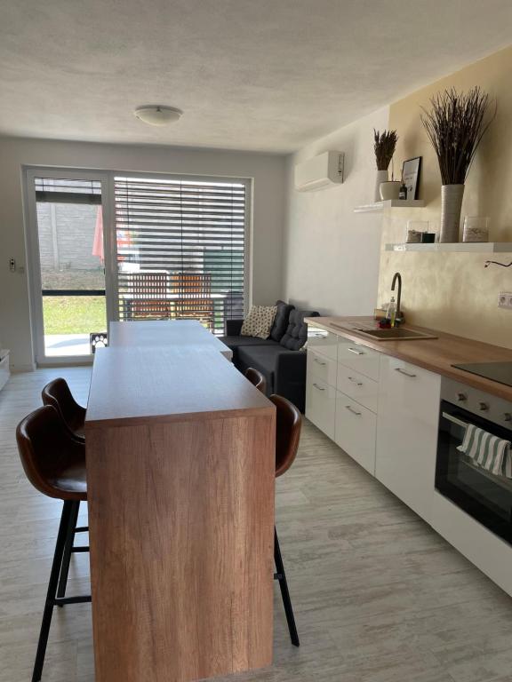 a kitchen with a island in the middle of a room at Sunny apartment on the lakes in Senec