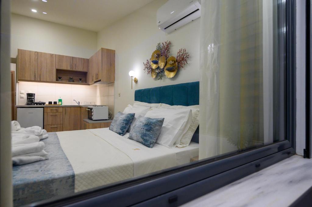 1 dormitorio con 1 cama grande con almohadas azules y blancas en Kalypso Apartments, en Kalamata