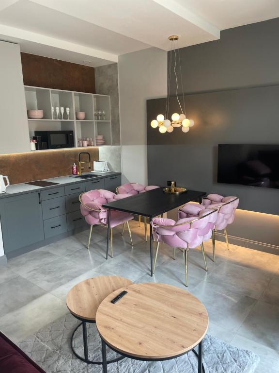 uma sala de jantar com uma mesa e cadeiras cor-de-rosa em Apartament na Starówce em Sandomierz