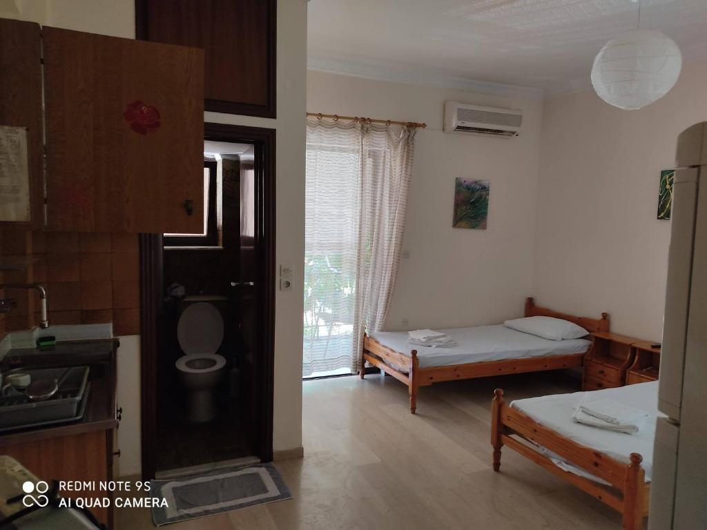 a room with a bedroom with a bed and a toilet at ROUSETIS APARTMENTS in Aigio