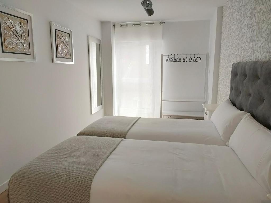 A bed or beds in a room at Second Home Arzúa apartamentos