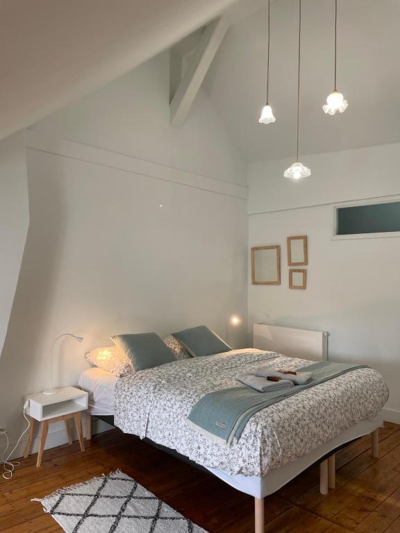 une chambre avec un lit dans une pièce blanche dans l'établissement Villa France Gall, à Trouville-sur-Mer