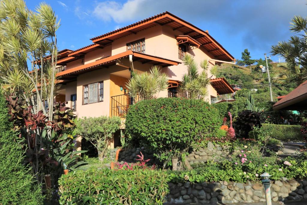 a house with a garden in front of it at Aparthotel Los Pinos in Boquete