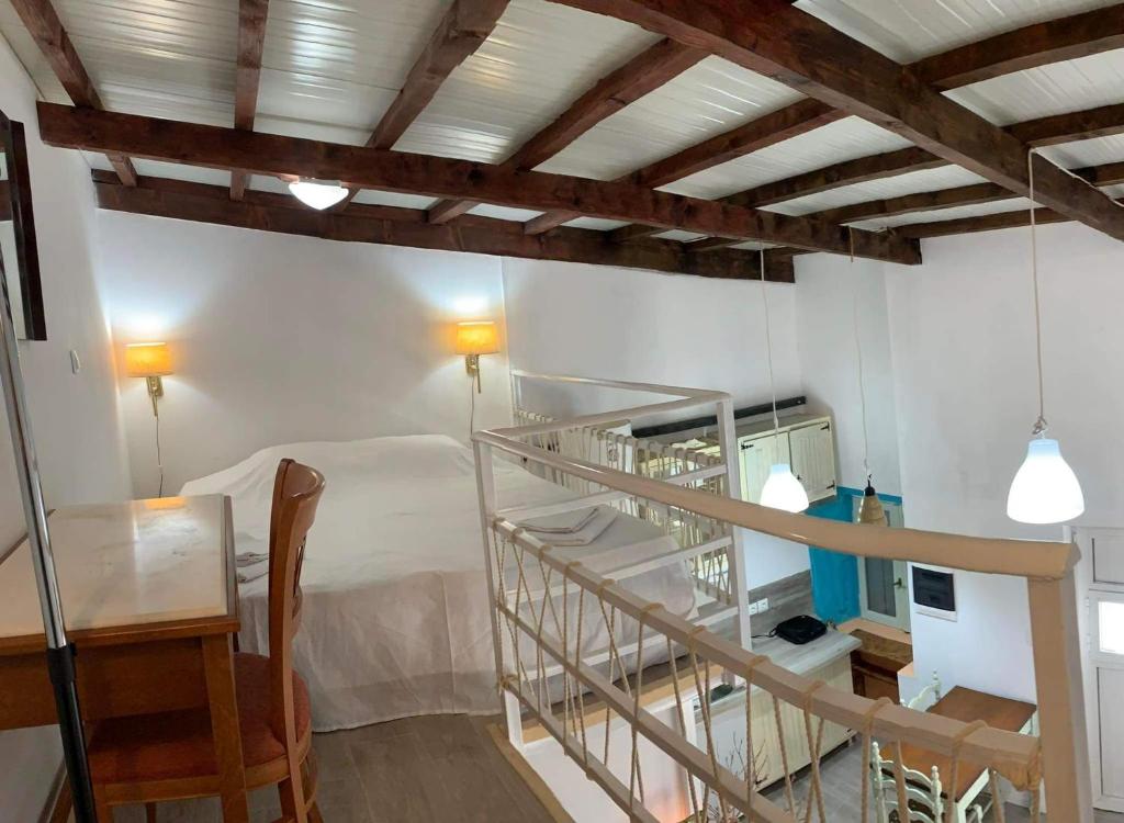 Habitación con escalera de caracol, mesa y silla en Loft Kapodistrias en Corfú